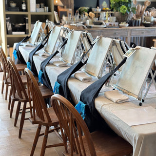 Long dining table set with chairs in a rustic kitchen setting