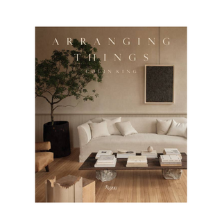 Book cover of 'Arranging Things' with a modern living room setting.