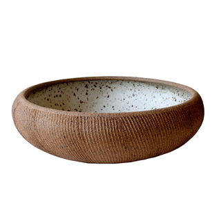 Ceramic bowl with textured brown exterior and speckled interior on a white background