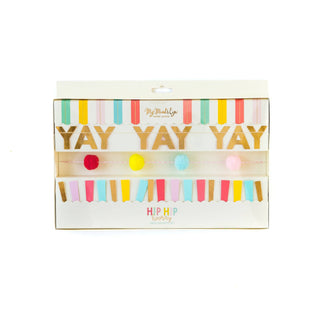 A set of three mini banners with the text 'YAY' in bold letters, decorated with colorful pom poms and ticker tape, presented in a clear packaging with a white background.