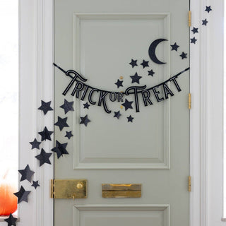 Decorative Halloween banner with 'Trick or Treat' on a door with star and moon decorations.