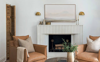 Living room with brown armchairs, a white fireplace, and decorative elements.