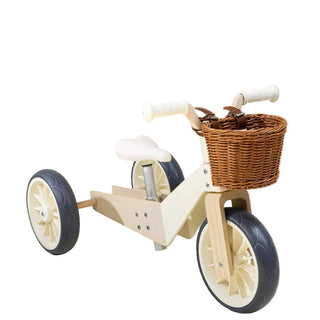 Wooden children's tricycle with a basket on a beige background