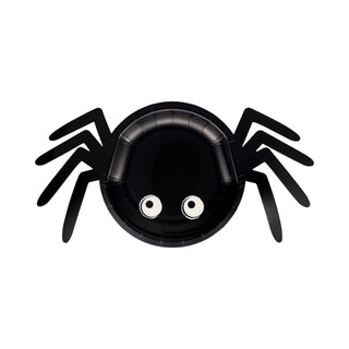 Black spider-shaped plate with googly eyes on a white background