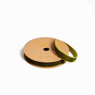 Spool of green ribbon on a wooden reel with a white background