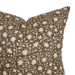 Decorative pillow with brown and beige floral pattern on a white background