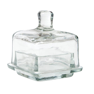 Clear glass butter dish with lid on a white background