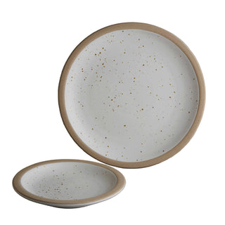 Two ceramic plates with beige rims on a neutral background