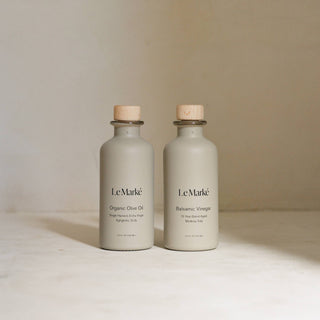 Two bottles of Le Marké on a light surface with a neutral background
