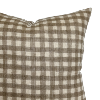 Checkered pillow with brown and white pattern on a white background