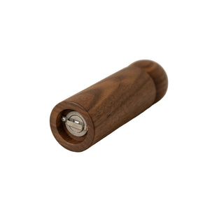 Wooden pepper grinder on a beige surface