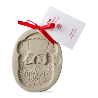Beige cookie mold with Santa Claus design and red ribbon packaging on a white background