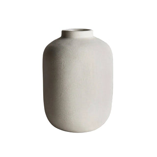 White ceramic vase on a gray surface with a light gray background