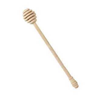 Wooden honey dipper on a marble surface