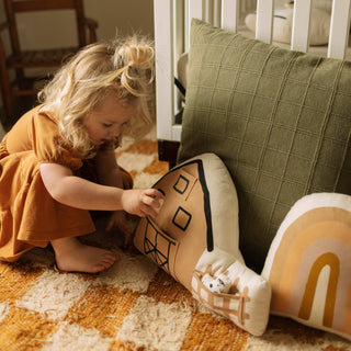 Child playing with a plush toy on a checkered floor