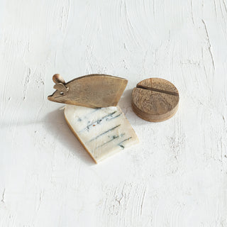 Cheese with a wooden and metal cheese knife on a white surface