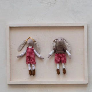 Set of small dolls in wooden frames on a light background