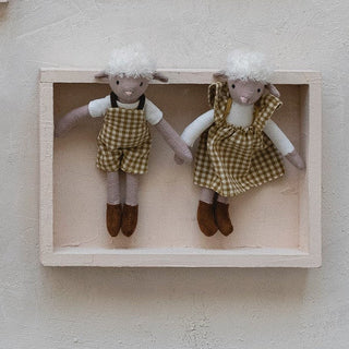 Set of small dolls in wooden frames on a light background