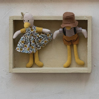 Set of small dolls in wooden frames on a light background