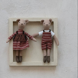 Set of small dolls in wooden frames on a light background