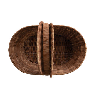 A natural brown woven wicker basket with a double-compartment design and two vertical handles, shown from a top-down view on a white background.
