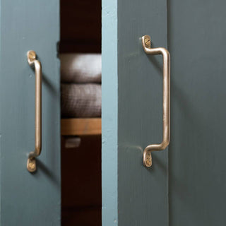 Close-up of a teal cabinet with gold handles