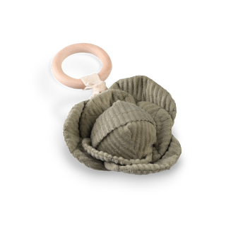 Knitted green baby rattle with a wooden ring on a white background