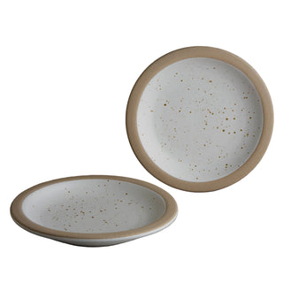 Two ceramic plates with speckled glaze on a neutral background