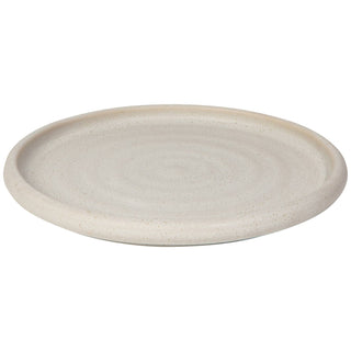 Round beige ceramic plate on a white background