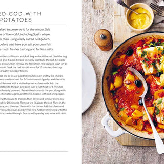 Home-salted cod with chorizo and potatoes in a pan on a wooden board, with text on the left side.