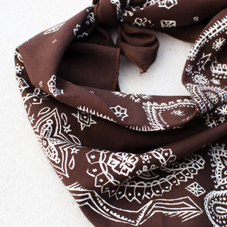 Brown bandana with white patterns on a white background