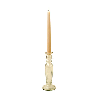 Clear glass candle holder with a lit beige candle on a beige background