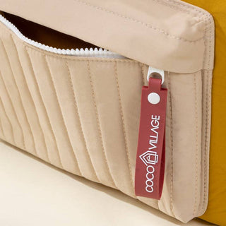 Close-up of a beige and mustard-colored bag with a red tag featuring 'Coco Village' branding.