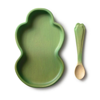 Green leaf-shaped plate and matching spoon on a white background