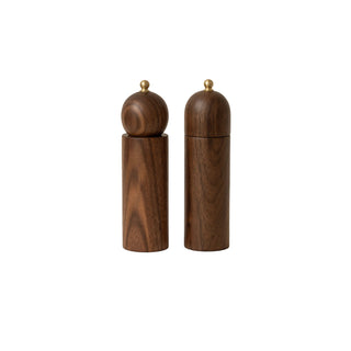 Wooden salt and pepper shakers with gold tops on a beige background