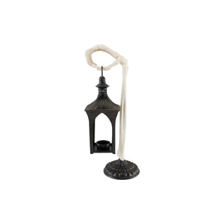 A gothic-style black metal lantern candle holder with a white skeleton hand holding the handle and a white skeleton arm draped down to the base, shown on a plain white background.